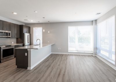 Kitchen with center island, appliances, large windows and hardwood floors in an apartment at the Residences at Bentwood in Plymouth Meeting